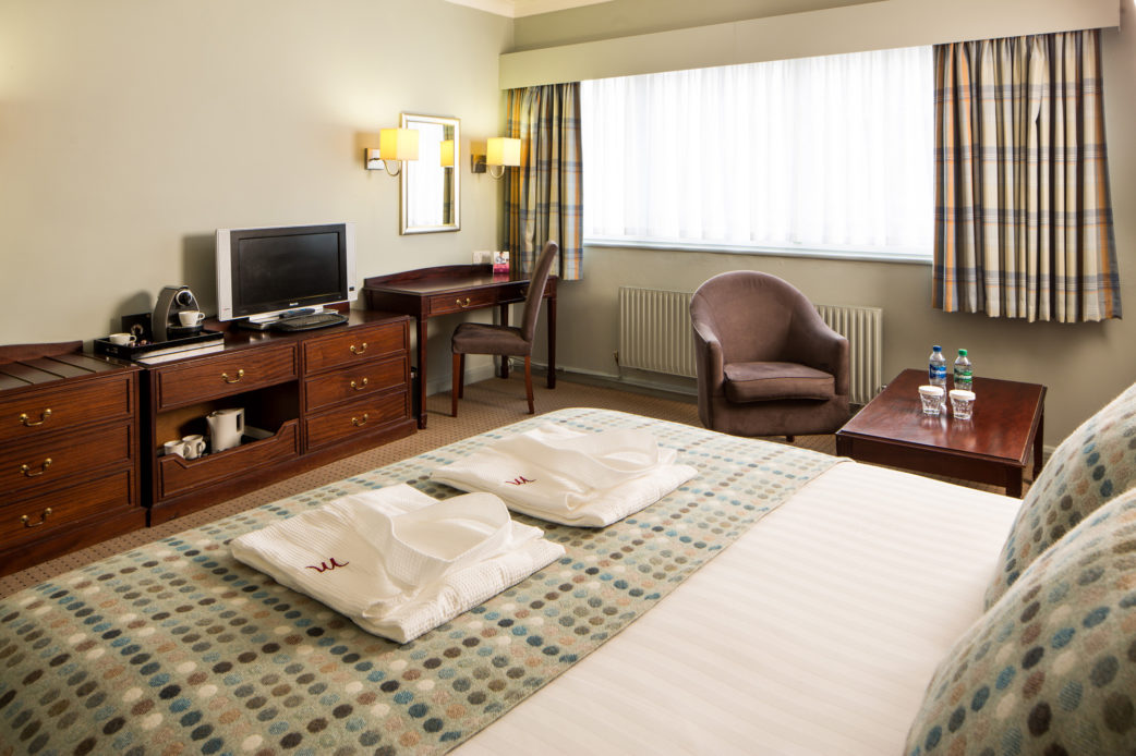 Angled view of Double bed desk and HDTV in a Privilege Room at Mercure Hotels