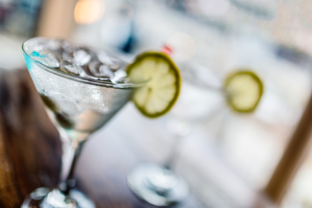 iStock-596797232-bar-martini-glasses-blurred Two glasses of classic martinis with ice on a hot Summer day. Selective focus on the foreground glass.