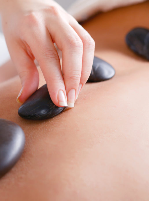 Woman enjoying a hot stone massage in a health club spa