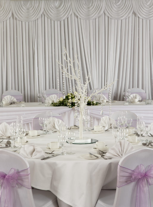 White and pink place settings at the head table of a wedding at Mercure Hotels
