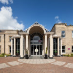 Exterior shot of Mercure York Fairfield Manor Hotel, driveway, columns, potted plants
