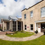 Exterior shot of Mercure York Fairfield Manor Hotel, driveway, columns, potted plants