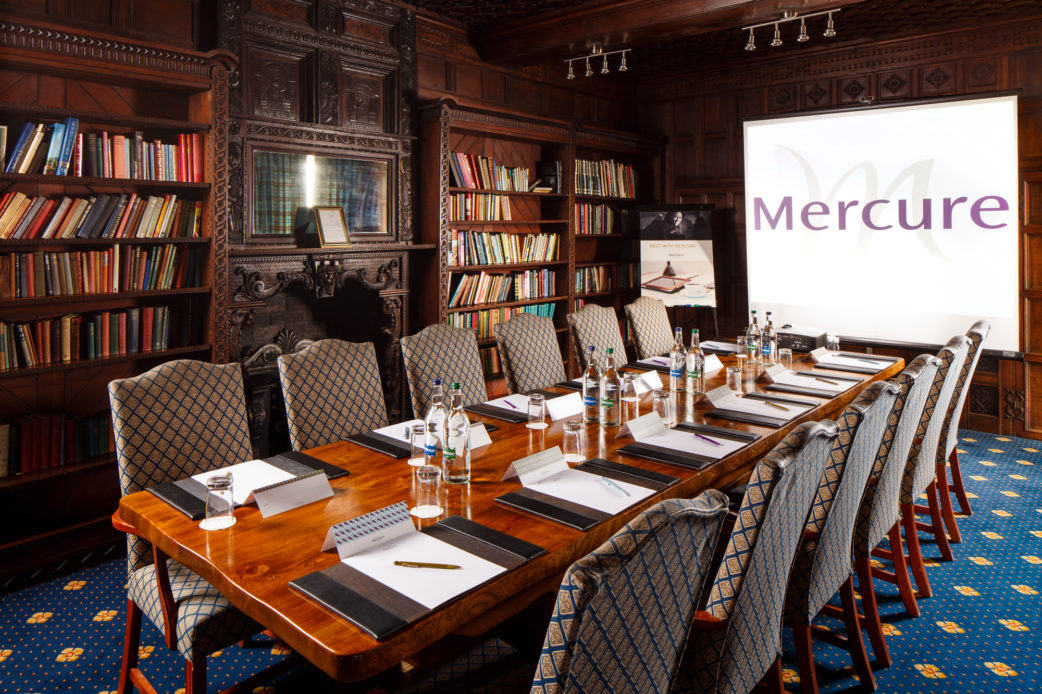 The Library meeting room, grand wood panelled library room set up for a board room style meeting