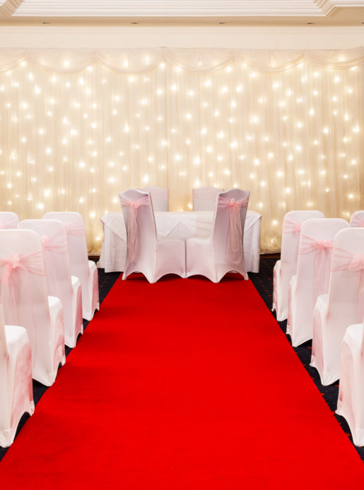 The Park Lane Suite at Mercure York Fairfield Manor Hotel, set up for a wedding ceremony, red carpet aisle, white fairy lights