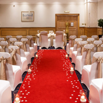 The Park Lane Suite at Mercure York Fairfield Manor Hotel, set up for a wedding ceremony, red carpet aisle, white and gold theme