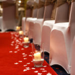 Close up of red carpet wedding aisle, candles