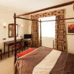 Superior bedroom at Mercure York Fairfield Manor Hotel, large four poster bed, desk, tv, mirror