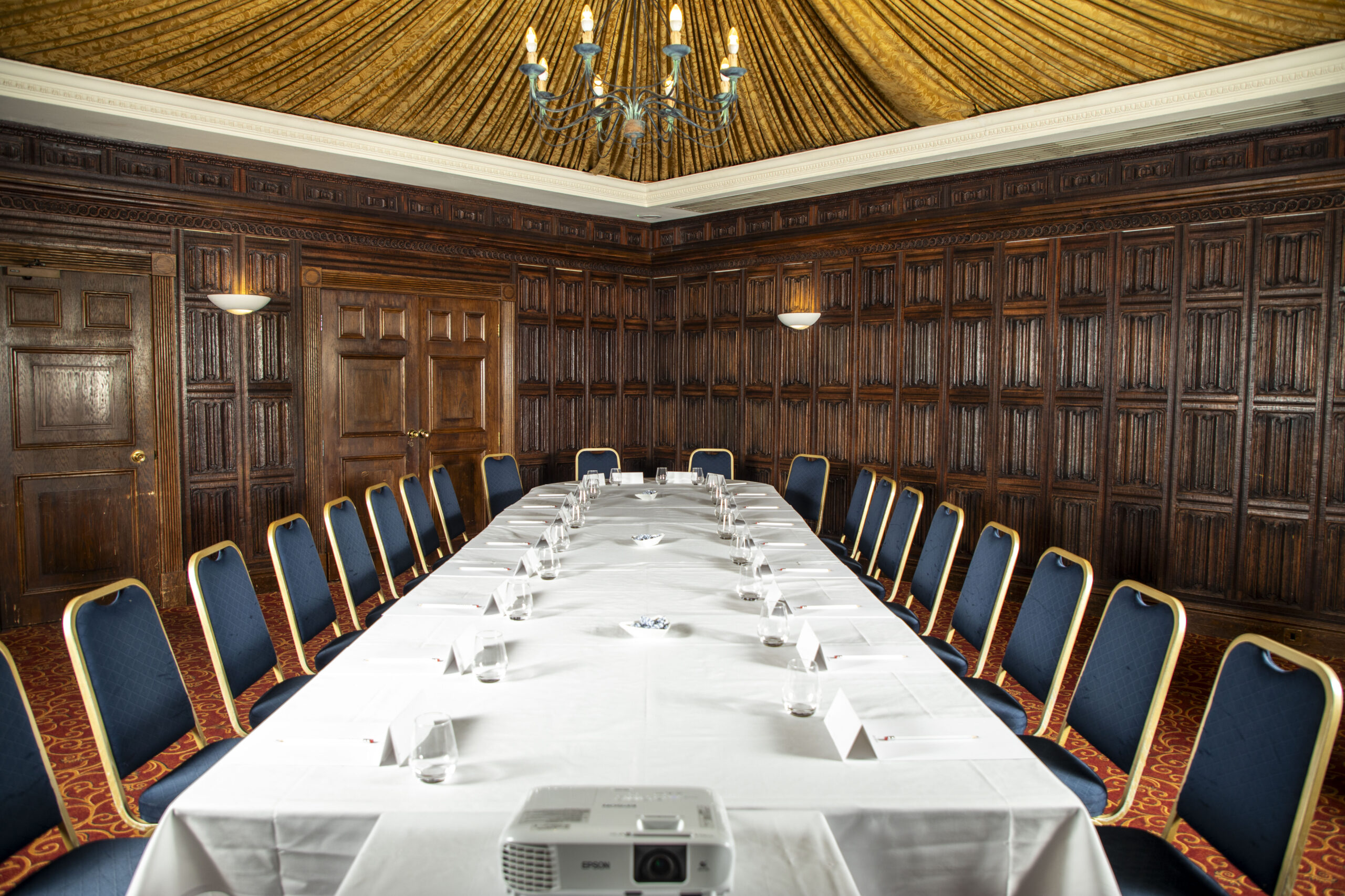 The Oak Room at Mercure York Fairfield Manor Hotel, original oak panelling and draped tented ceiling, chandelier, set up for a meeting